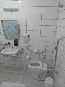 a bathroom with a toilet and a sink at Rota do Sol Praia Hotel in Guaratuba