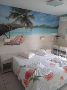 a bedroom with a bed with a mural of a beach at Rota do Sol Praia Hotel in Guaratuba