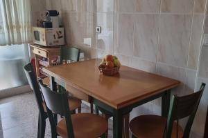 a wooden table with a basket of fruit on it at Duplex excelente situación in Narón +8 photos