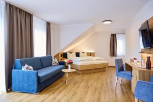 sala de estar con sofá azul y cama en Brauerei Gasthof Reblitz, en Bad Staffelstein