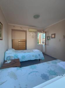 Un dormitorio con dos camas y una mesa dentro. en Casiopea Apart, en San Fernando del Valle de Catamarca