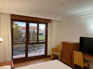 um quarto de hotel com vista para uma varanda em Gran Hotel Liber & Spa Playa Golf em Noja