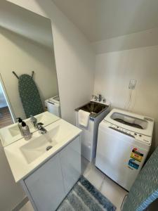una piccola cucina con lavandino e piano cottura di Modern Home by the Reserve ad Auckland