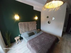 1 dormitorio con cama y pared verde en Le 18 by Benson, en Bollène
