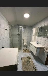 a bathroom with a sink and a toilet and a shower at A&F apartment in Pristina