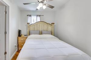 a bedroom with a large white bed with a ceiling fan at Charming Sylvester Apartment - 17 Mi to Albany! in Sylvester