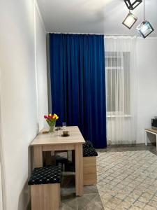 Zimmer mit einem Tisch und einem blauen Vorhang in der Unterkunft Жилой комплекс Махаббат in Aqtau