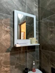 a bathroom with a mirror on a tiled wall at Жилой комплекс Махаббат in Aktau