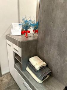 ein Badezimmer mit einer Theke mit Handtüchern und einem Spiegel in der Unterkunft Жилой комплекс Махаббат in Aqtau