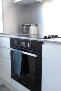 a black oven with a towel hanging from it in a kitchen at Penthouse Studio by Regent's Park/Euston in London