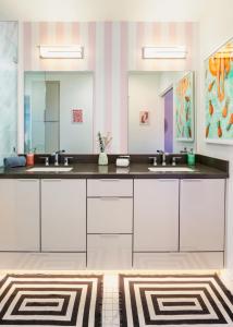 uma casa de banho com dois lavatórios e dois espelhos em Caliente Oasis - A Ryson Property em Palm Springs
