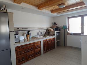 a large kitchen with wooden cabinets and a large window at Tatry TOP Dom in Vavrišovo