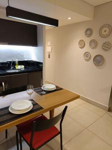 a dining room with a table with plates and wine glasses at Apartamentos & Flats La Residence Paulista in Sao Paulo