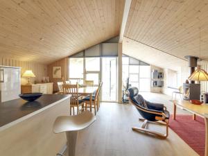 cocina y sala de estar con mesa y sillas en Holiday Home Emelia - 50m from the sea in NW Jutland by Interhome, en Torsted