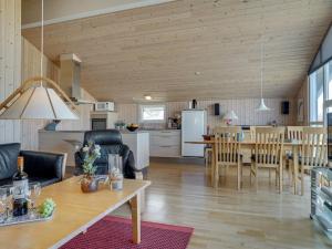 cocina y sala de estar con mesa y sillas en Holiday Home Emelia - 50m from the sea in NW Jutland by Interhome, en Torsted