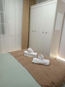 1 dormitorio con 1 cama con toallas en APARTAMENTO MENCER, en Malpica de Bergantiños