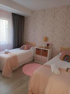 a bedroom with two beds and a window at APARTAMENTO MENCER in Malpica