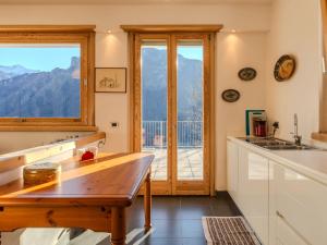 a kitchen with a table and a large window at Holiday Home Vitali by Interhome in Taceno