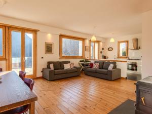 a living room with two couches and a kitchen at Holiday Home Vitali by Interhome in Taceno