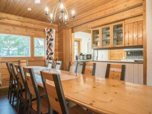 a dining room with a large wooden table and chairs at Holiday Home Pihlaja 8 by Interhome in Isnäs