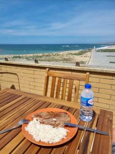 un piatto di cibo su un tavolo con una bottiglia d'acqua di Beach house Lavra a Lavra