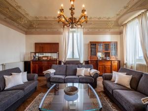 a living room with couches and a chandelier at Holiday Home Villa Loreto by Interhome in Costigliole dʼAsti