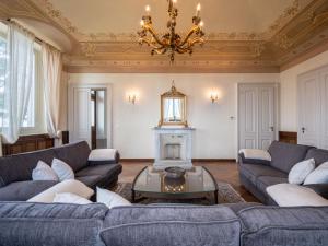 a living room with couches and a chandelier at Holiday Home Villa Loreto by Interhome in Costigliole dʼAsti