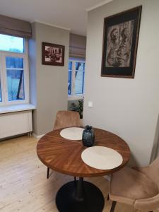 a living room with a wooden table and chairs at Vokės parko apartamentai in Vilnius