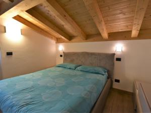 Ce lit se trouve dans un dortoir doté de plafonds en bois. dans l'établissement Apartment Santa Croce View Apartment by Interhome, à Civo