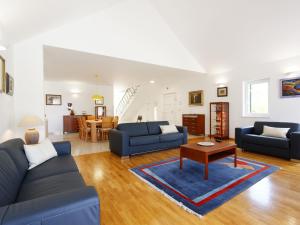 una sala de estar con sofás azules y una mesa. en Holiday Home Villa Župa by Interhome, en Roglići
