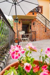 un patio con una sombrilla blanca y flores rosas en La Carteria casa rural, en Cangas de Onís