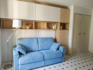 Sofá azul en la sala de estar con lámpara en Apartment Jardins de la mer-10 by Interhome, en Saint-Cyr-sur-Mer
