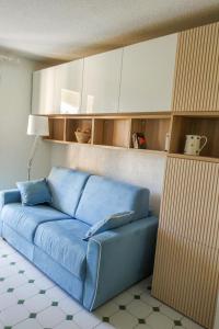 un sofá azul en una sala de estar con armarios blancos en Apartment Jardins de la mer-10 by Interhome, en Saint-Cyr-sur-Mer