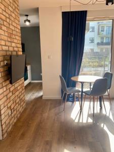 uma sala de jantar com mesa e cadeiras e uma parede de tijolos em Chillout Loft Apartment AL20 em Varósvia