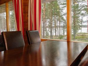 uma mesa de jantar com cadeiras e uma grande janela em Holiday Home Kanerva 4 by Interhome em Isnäs