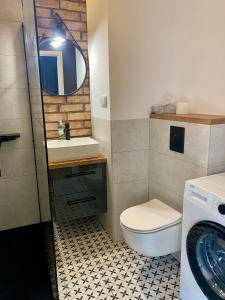 bagno con servizi igienici, lavandino e specchio di Chillout Loft Apartment AL20 a Varsavia