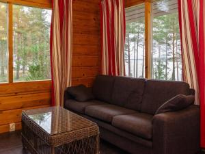 uma sala de estar com um sofá e uma mesa em Holiday Home Kanerva 4 by Interhome em Isnäs