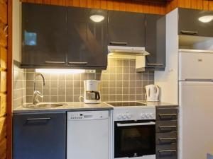 uma cozinha com armários pretos e um aparelho branco em Holiday Home Kanerva 4 by Interhome em Isnäs