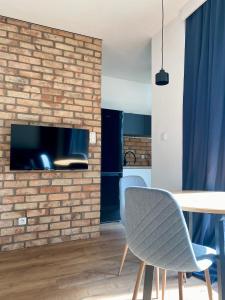 Chillout Loft Apartment AL20 في وارسو: غرفة معيشة بجدار من الطوب وطاولة وكراسي