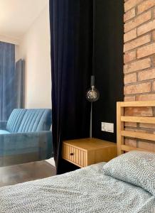 een slaapkamer met een bed en een blauwe bank bij Chillout Loft Apartment AL20 in Warschau