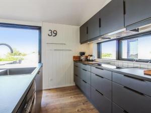uma cozinha com armários cinzentos e uma grande janela em Holiday Home Kristiina - 500m from the sea in NW Jutland by Interhome em Saltum