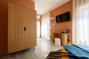 a bedroom with a large closet and a tv on the wall at Pavean Suites Frattamaggiore in Frattamaggiore