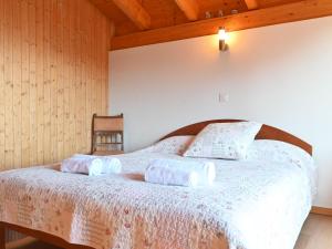 a bedroom with a bed with two pillows on it at Chalet Orchidée by Interhome in Ovronnaz