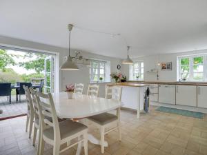 een keuken en eetkamer met een witte tafel en stoelen bij Holiday Home Seppo - 1-4km to the inlet in The Liim Fiord by Interhome in Ranum