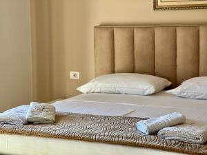 a bed with two towels sitting on top of it at Apartments Klajdi in Sarandë