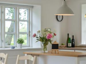 een keuken met een vaas met bloemen op een tafel bij Holiday Home Seppo - 1-4km to the inlet in The Liim Fiord by Interhome in Ranum