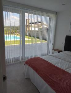 een slaapkamer met een groot raam met uitzicht op een zwembad bij Villa Cariño - Apartamento en Malpica de Bergantiños in Malpica