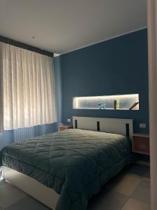 a bedroom with a bed and a blue wall at Tra mare e castello in Barletta