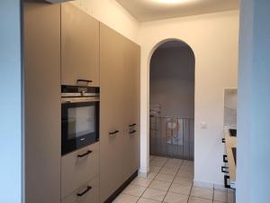 a hallway with a kitchen with a television and an archway at Holiday Home Villa Miralago by Interhome in Agno