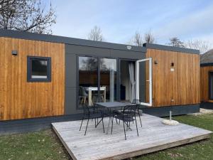 ein kleines Haus mit einem Tisch und Stühlen auf einer Terrasse in der Unterkunft Holiday Home Tiny Haus Burgblick by Interhome in Riedenburg